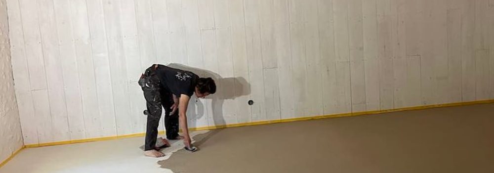 Sylvie, artisane en Dordogne, applique du béton banché pour un sol intérieur
